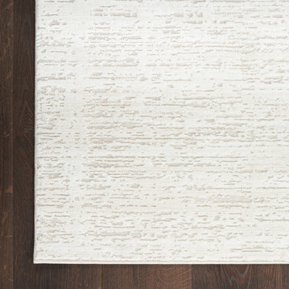 Rectangular cream textured area rug with subtle ivory pattern on dark wood flooring.