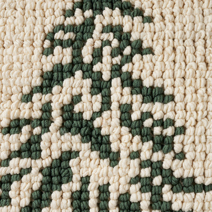 Close-up of a cream-beige chunky-loop rug with dark green geometric motif and textured weave
