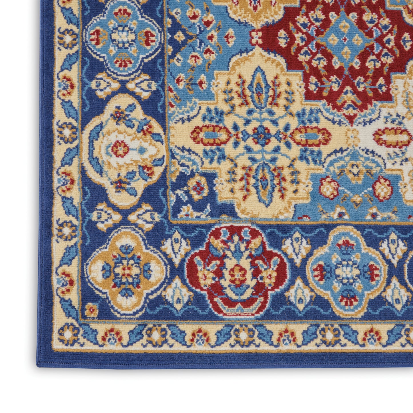 Woven wool rug close-up in blue, ivory, and red with ornate floral medallions and layered borders.
