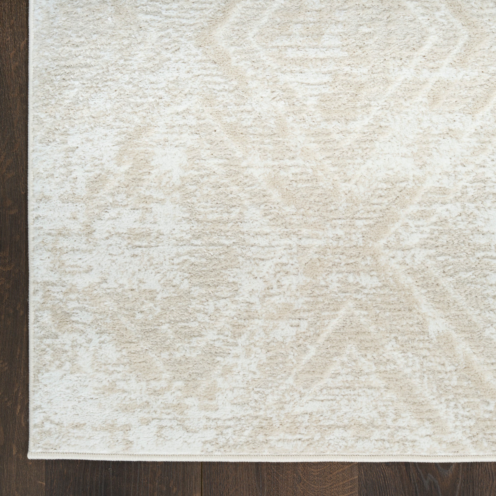 Cream textured rug with subtle damask pattern on dark wood floor; plush rectangular area rug for living room.