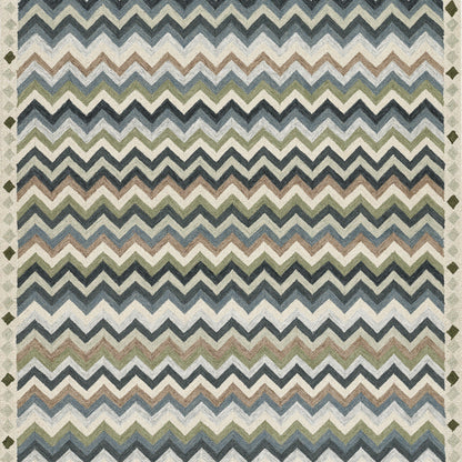 Chevron-pattern rug in blue, green, and ivory tones with zigzag stripes on a neutral floor.