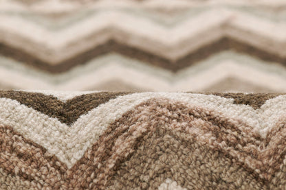Close-up of a plush beige, cream and brown chevron rug with a soft pile texture.
