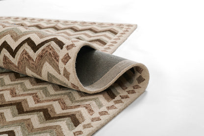 Zigzag stripe area rug in beige, taupe and cream; rolled edge reveals grey underside.