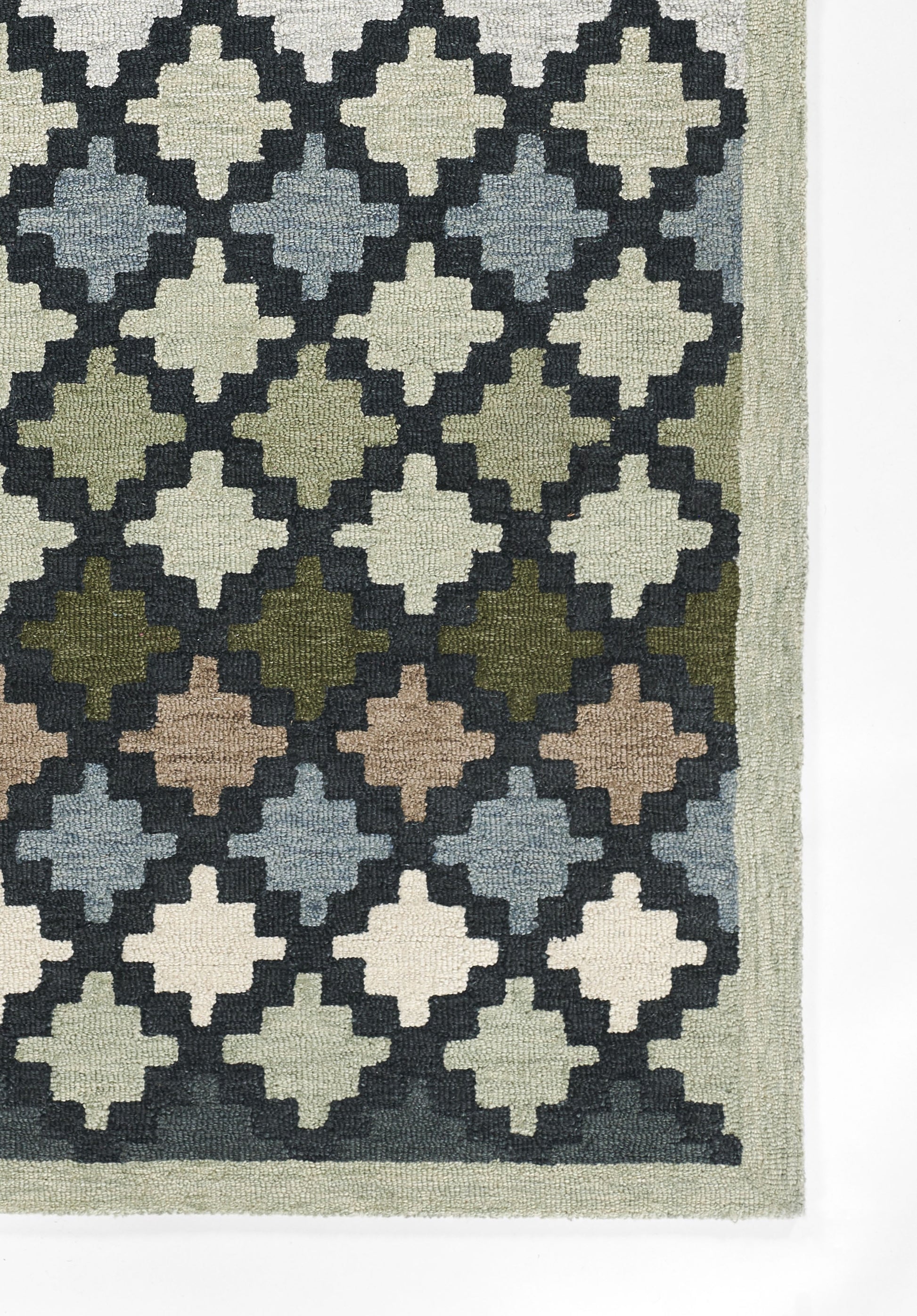 Woven area rug with a repeating diamond trellis pattern in cream, navy, blue-gray, greens and browns; pale sage border.