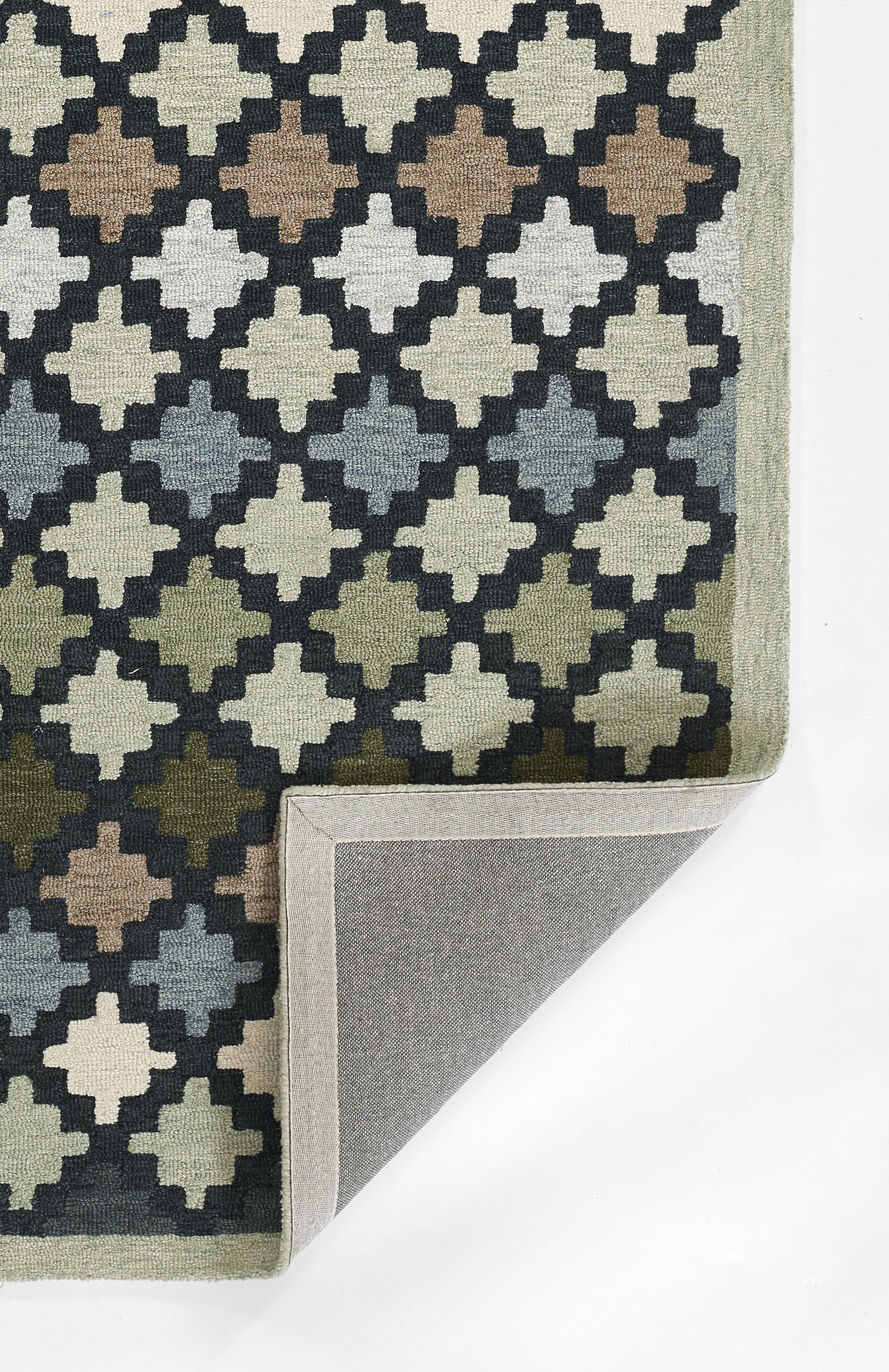 Geometric rug with a diamond trellis pattern in navy, cream, tan, gray and olive; folded corner reveals gray backing.
