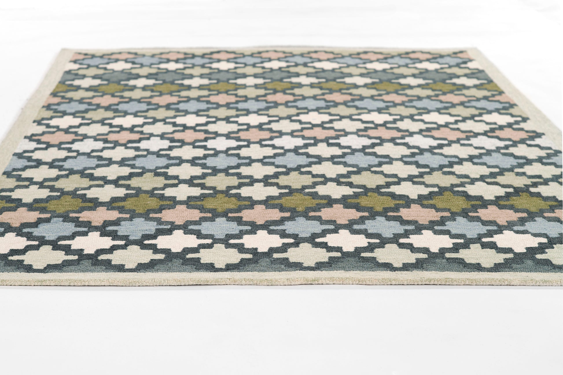 Rectangular blue-and-cream flatweave rug with diamond trellis pattern, pink/olive accents, beige border.