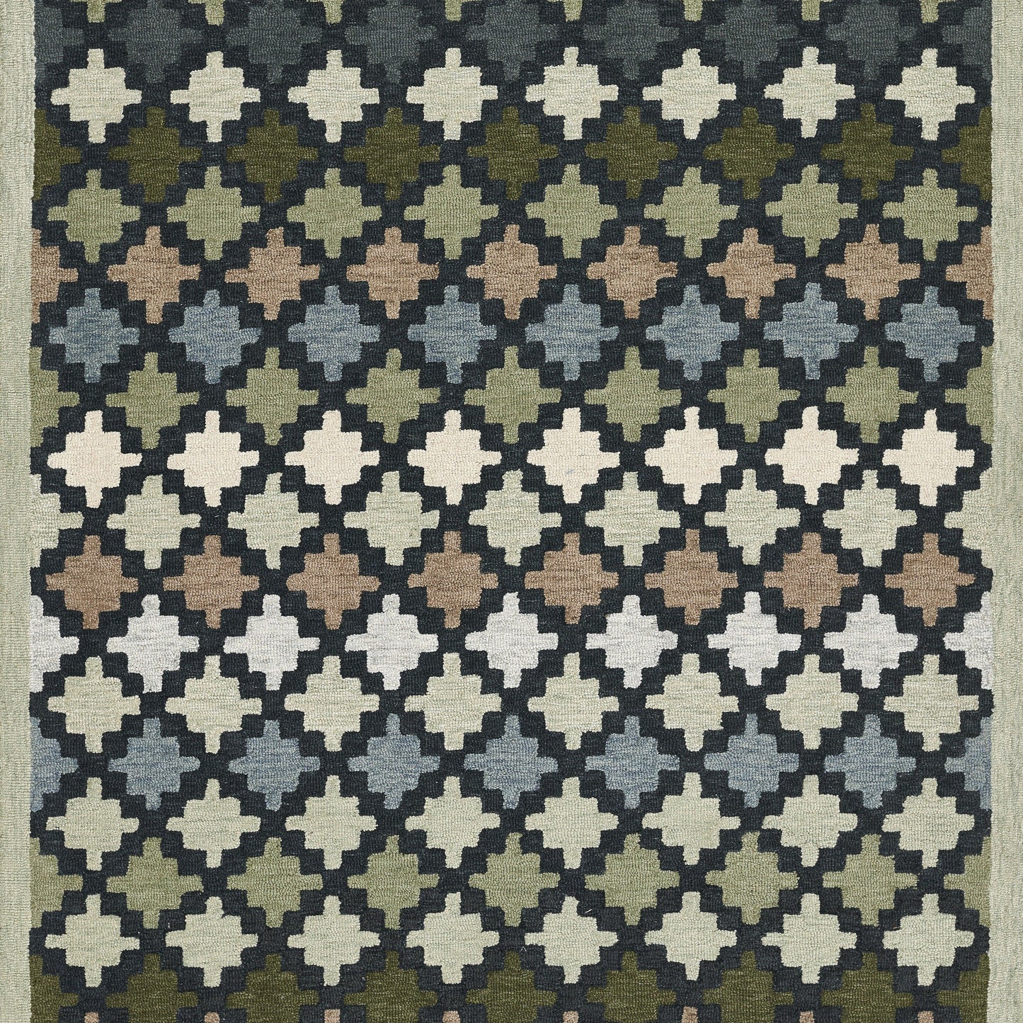 Woven rug with a diamond lattice of cross-like quatrefoil motifs in a gradient of blues, greens, browns and creams.