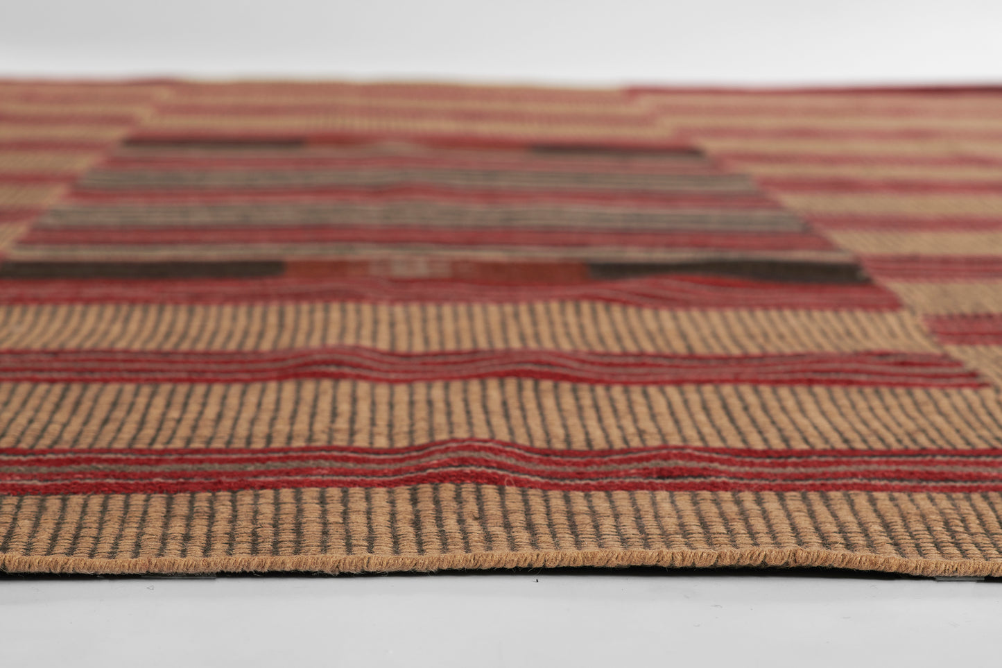 Handwoven jute area rug with natural beige base and red striped pattern; rustic boho style.