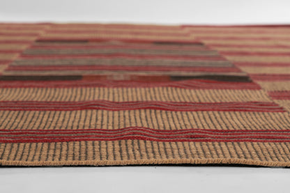 Rectangular natural jute rug with red stripe patterns and earthy tones; rustic boho style.