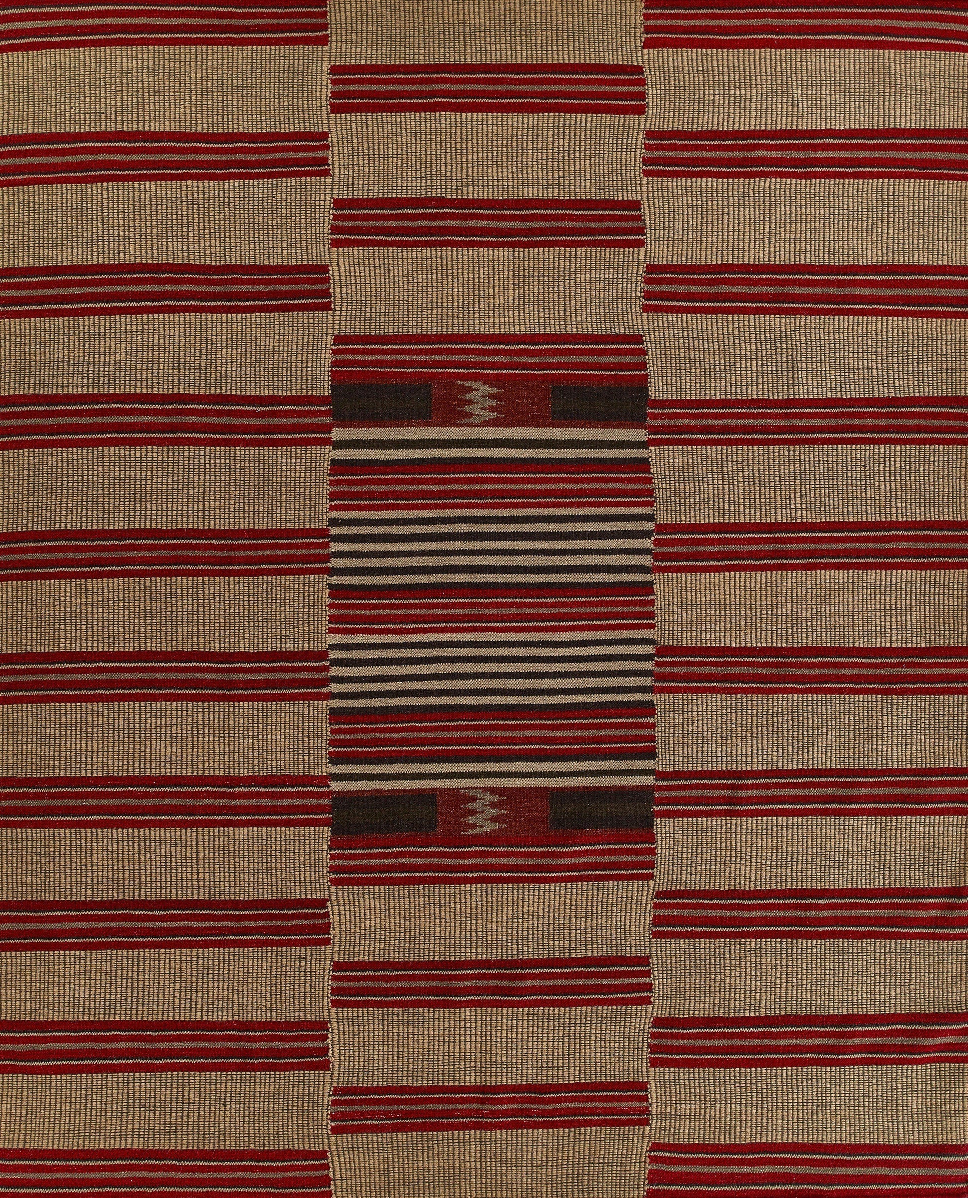 Beige flat-weave kilim rug with red horizontal stripes and a central multicolor geometric panel in burgundy, black and cream.