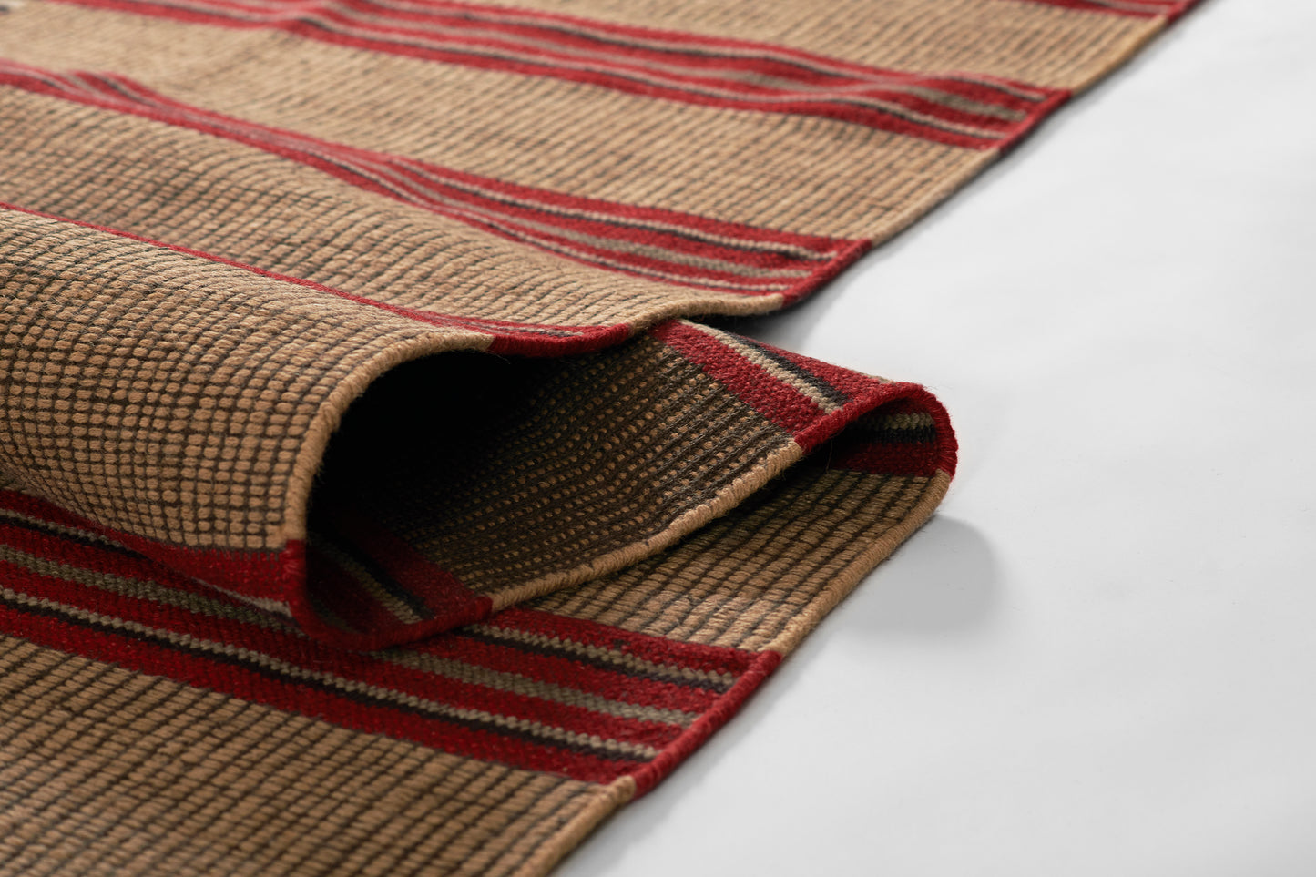 Natural beige jute rug with bold red stripes, woven texture, rolled edge, rustic coastal style for living room or hallway.