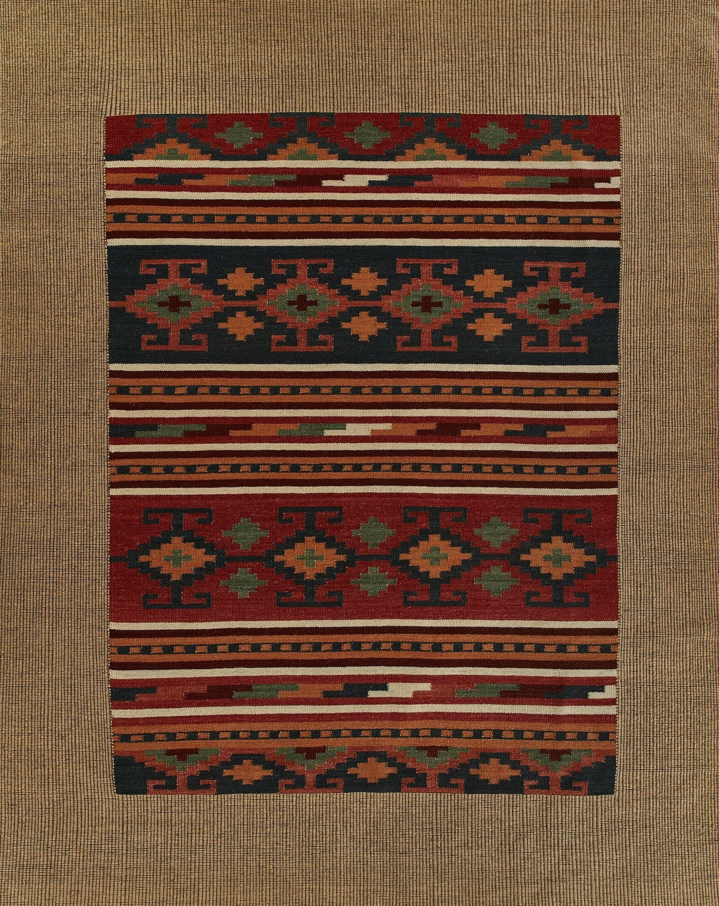 Rectangular kilim rug with geometric patterns in red, navy, green and ivory; flat-weave tribal floor decor.