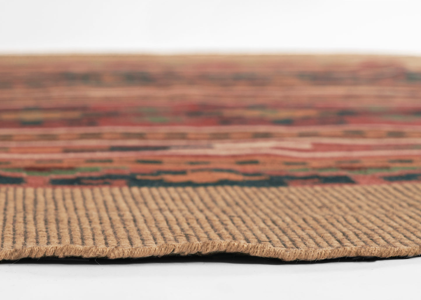 Close-up of a multicolor kilim-pattern rug with a beige woven border and earthy tones.