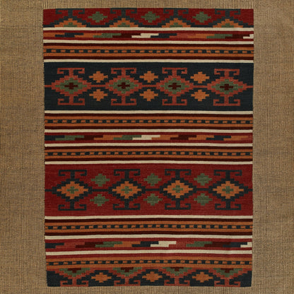 Rectangular kilim-style wool rug featuring bold geometric tribal motifs in red, navy, orange, green, cream.
