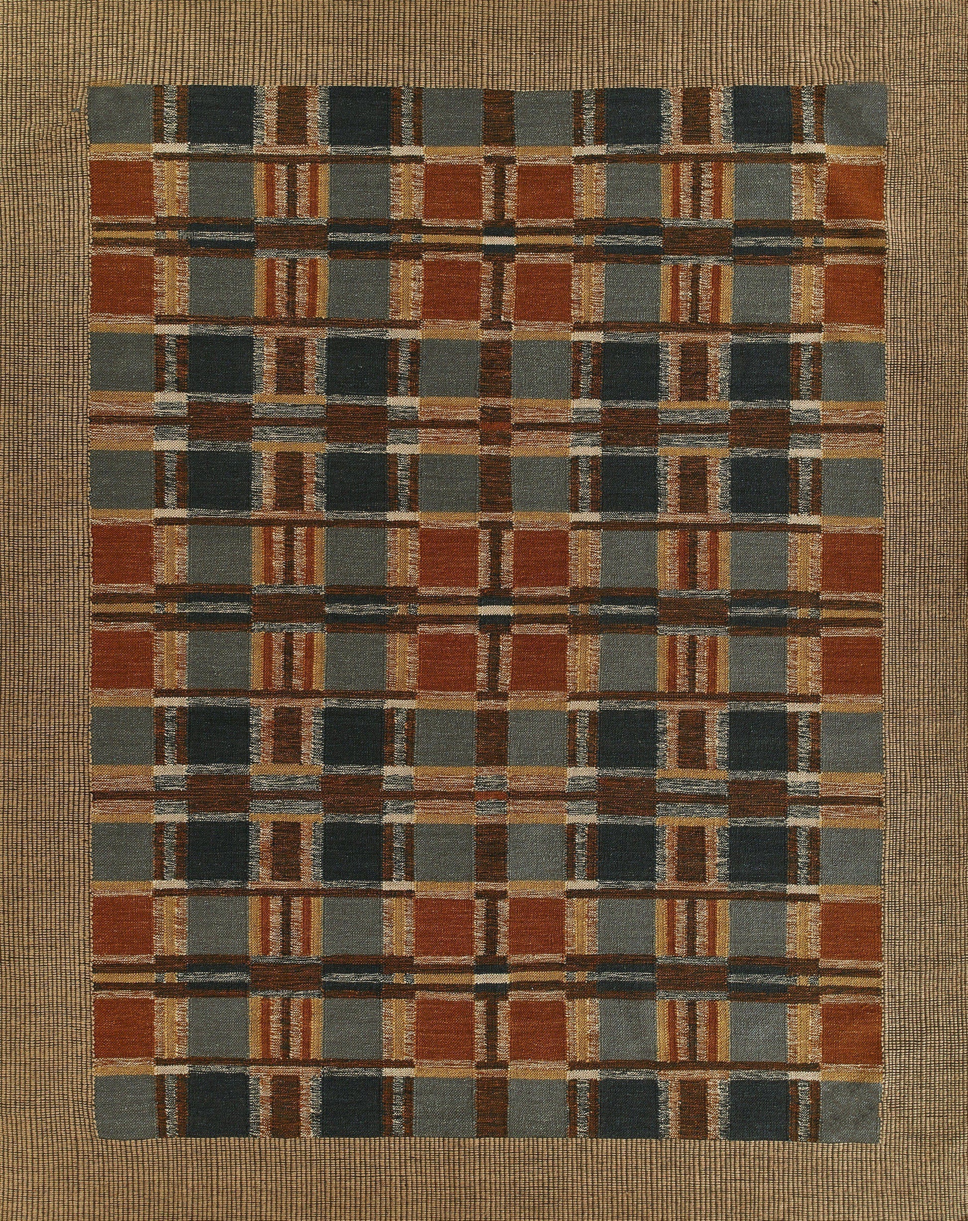 Rectangular woven rug with a multicolor plaid grid of rust, navy, tan and gray squares; rustic geometric style.