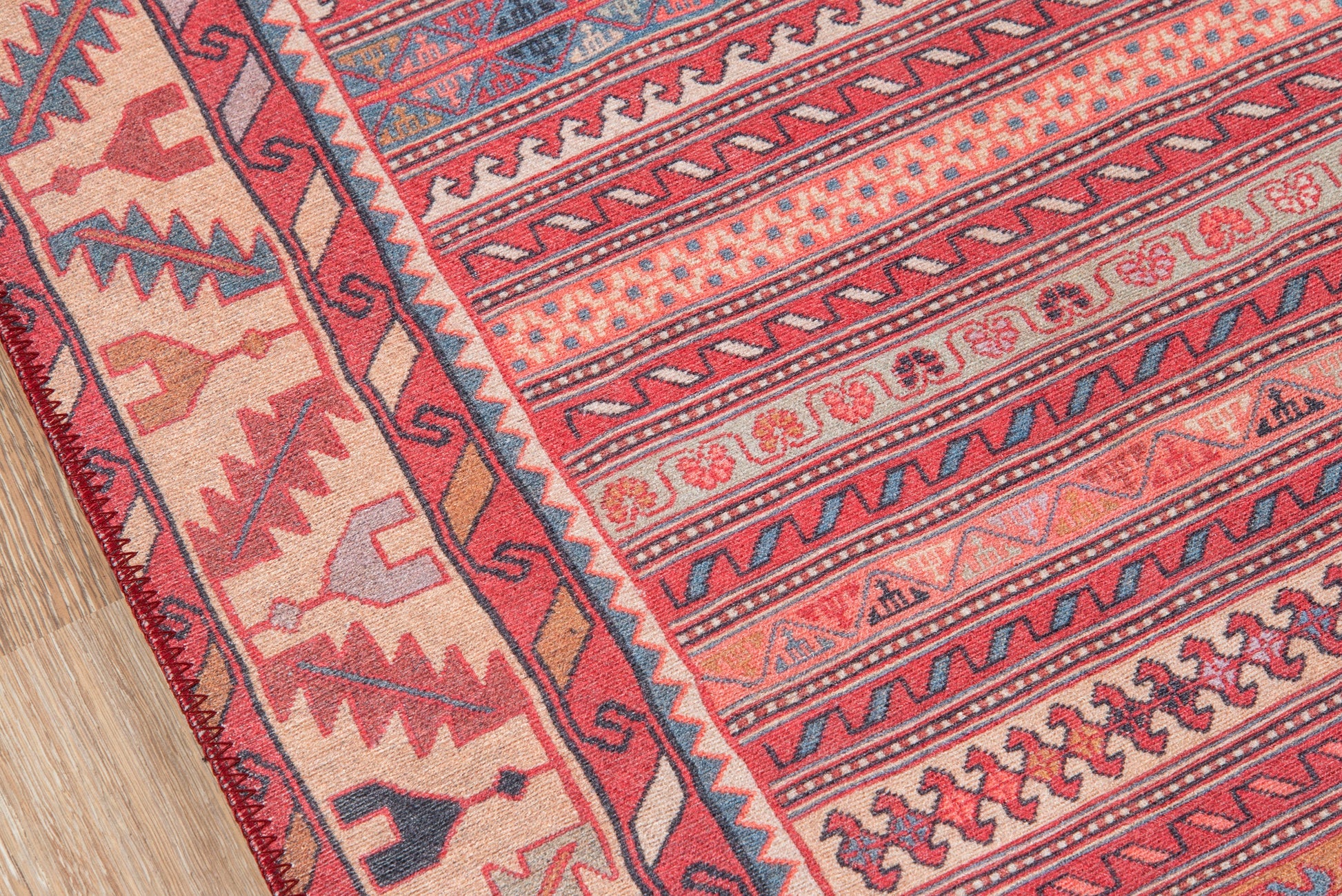 Vibrant woven area rug with red, pink, and blue geometric tribal patterns and decorative border, size 2' x 3'.