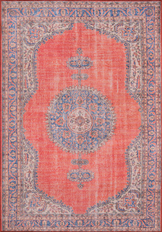 Rectangular Persian-style rug with coral red field, large central blue medallion, and blue-cream floral border.
