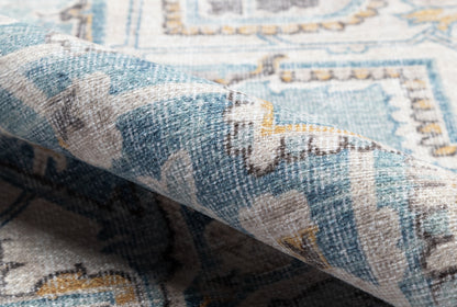 Blue and ivory woven area rug with teal accents, ornate geometric floral border, soft textured pile.