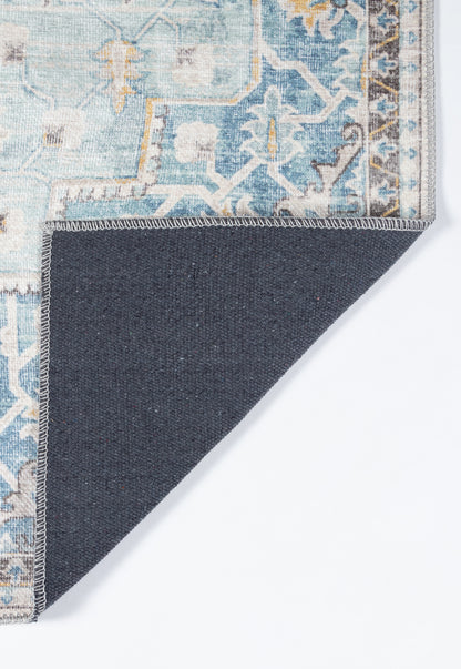 Blue distressed oriental rug with ivory and yellow floral motifs and geometric border; navy underside shown at corner.