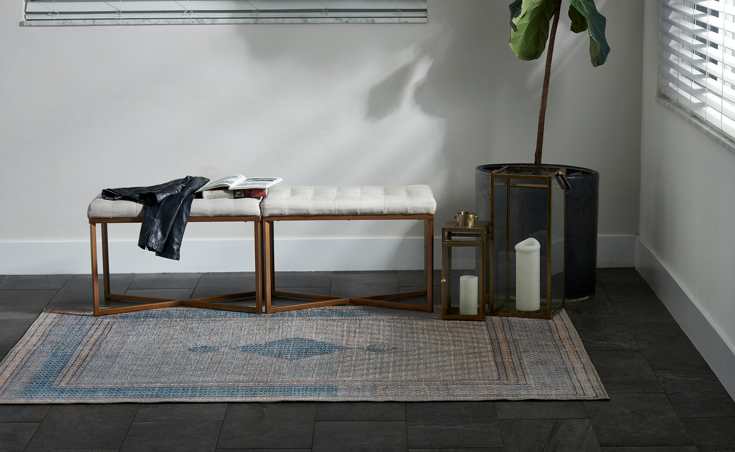 Blue-gray runner rug with a leather jacket, an open magazine, and lanterns.