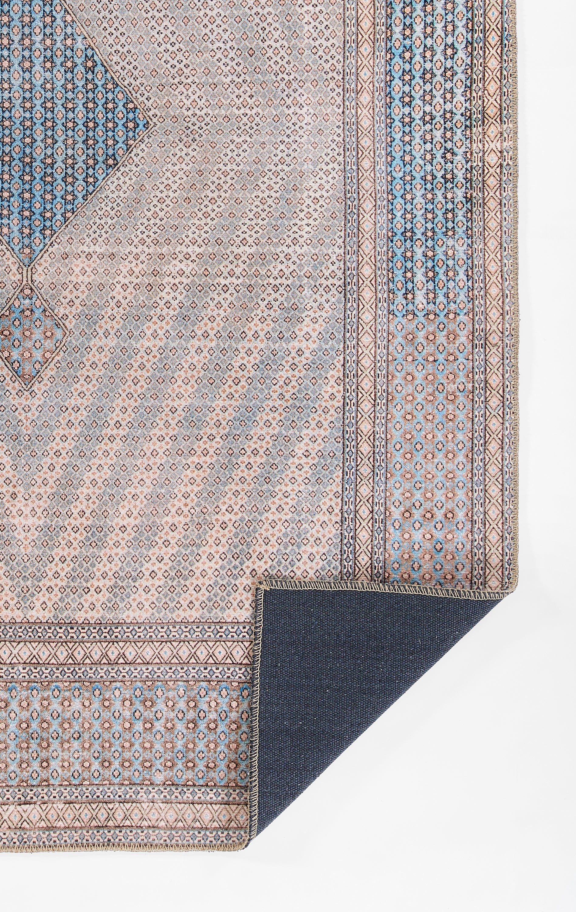 Blue and beige Persian-inspired woven runner with geometric medallions and borders; corner folded to reveal navy backing