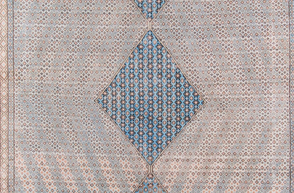 Blue and beige geometric rug featuring a central blue diamond medallion with repeating small motifs.