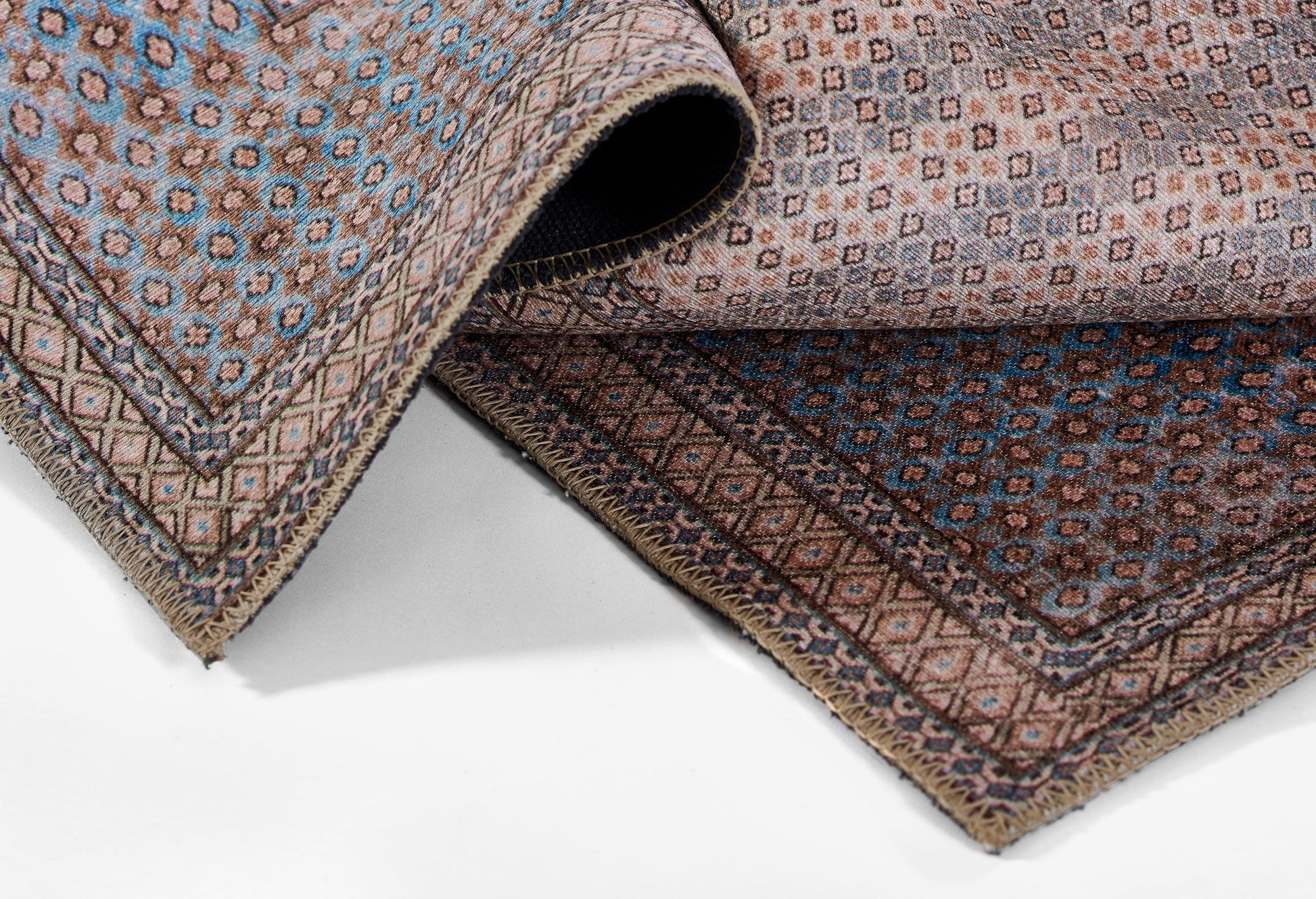 An oriental woven runner rug in blue, brown and beige with geometric borders and fringed edges.