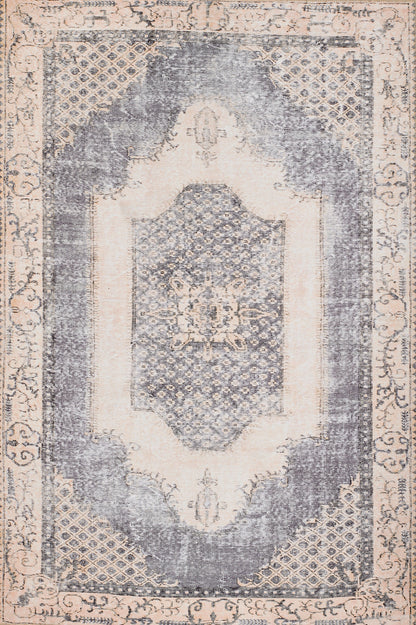 Distressed vintage oriental rug in cream and blue-gray, with a central medallion, lattice corners and ornate border.