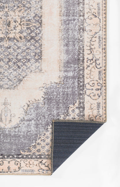 Blue and beige vintage-style area rug with ornate border; folded corner shows dark underside.