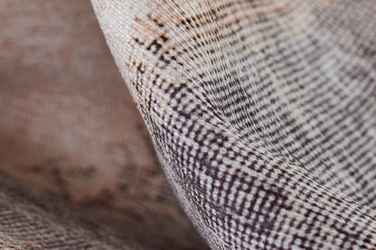 Close-up of brown & cream checkered woven rug with textured tweed-like fibers.