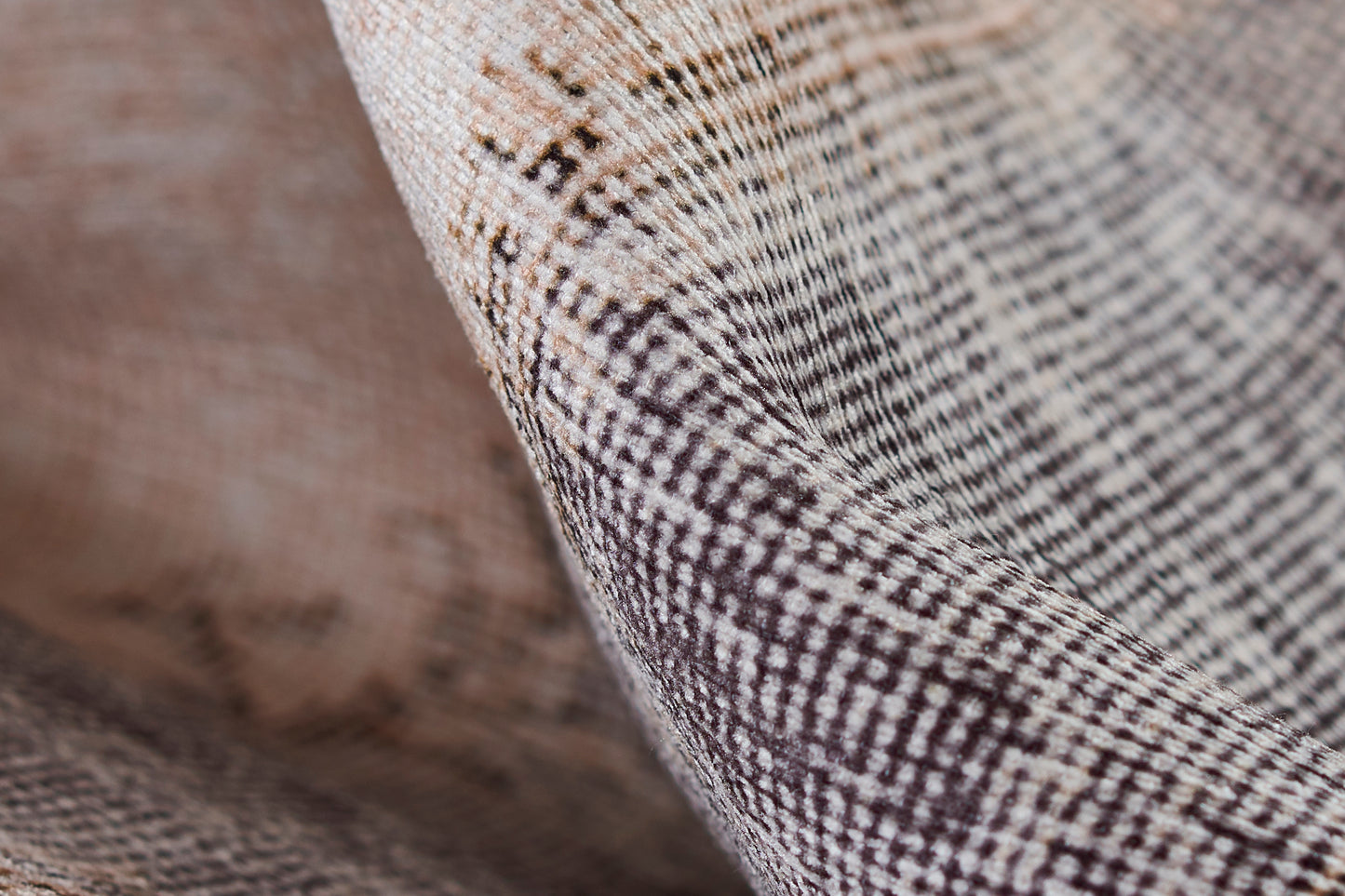 Close-up of beige-brown woven plaid fabric with a fine texture and linen-like drape.