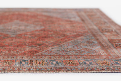 Traditional red Persian-style rug with blue & cream geometric border & fringed edge.