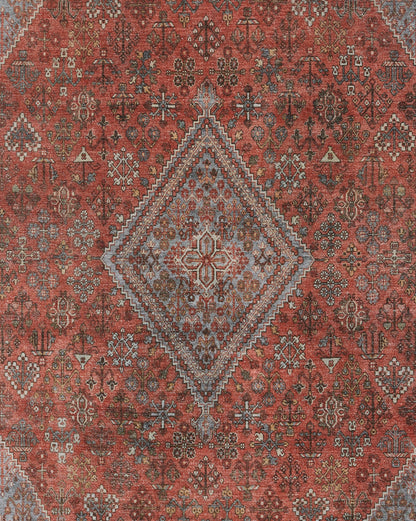 Rust-red oriental rug with a blue-gray diamond medallion, intricate floral-geometric motifs and a warm distressed look.
