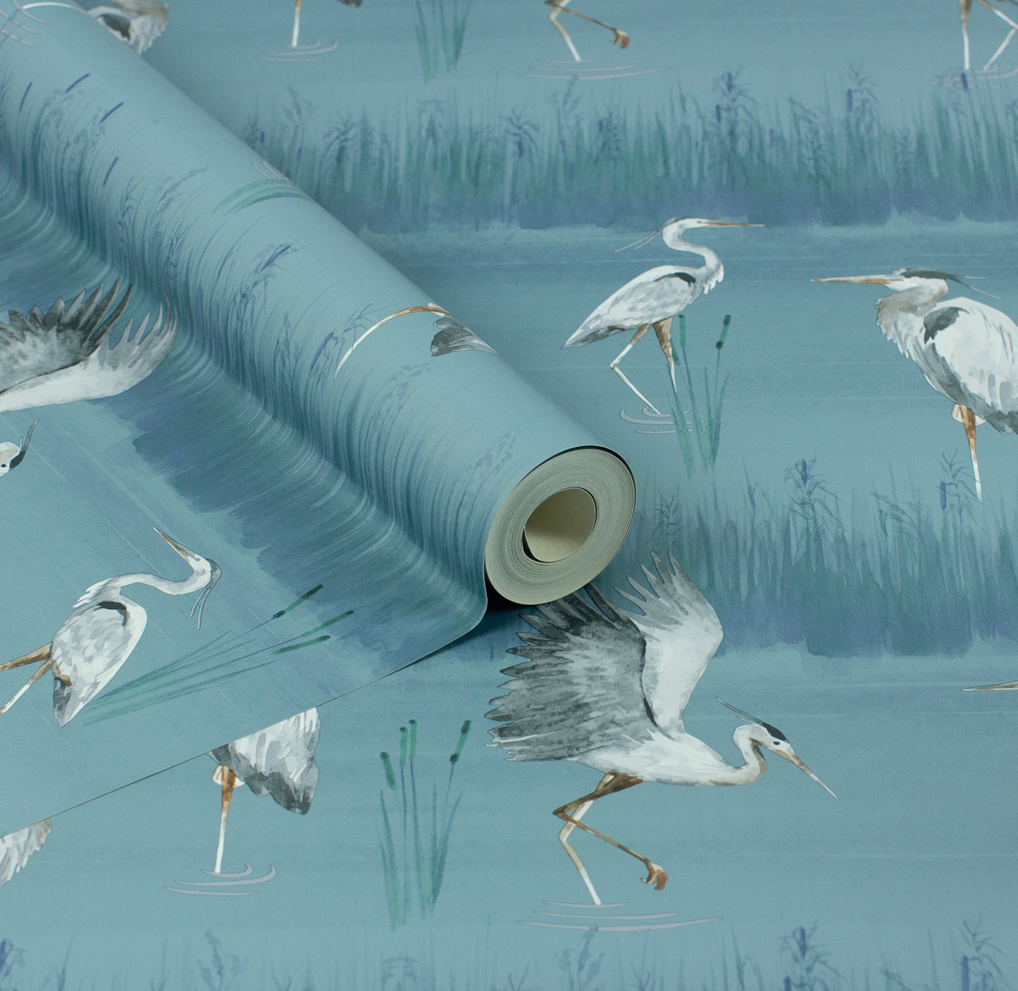 Blue wallpaper roll with a marsh scene featuring white herons wading among green reeds.