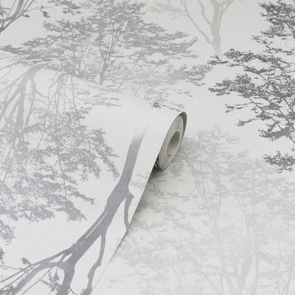 Gray-scale forest/tree branch wallpaper roll with rolled edge on a pale background; decorative wallcovering