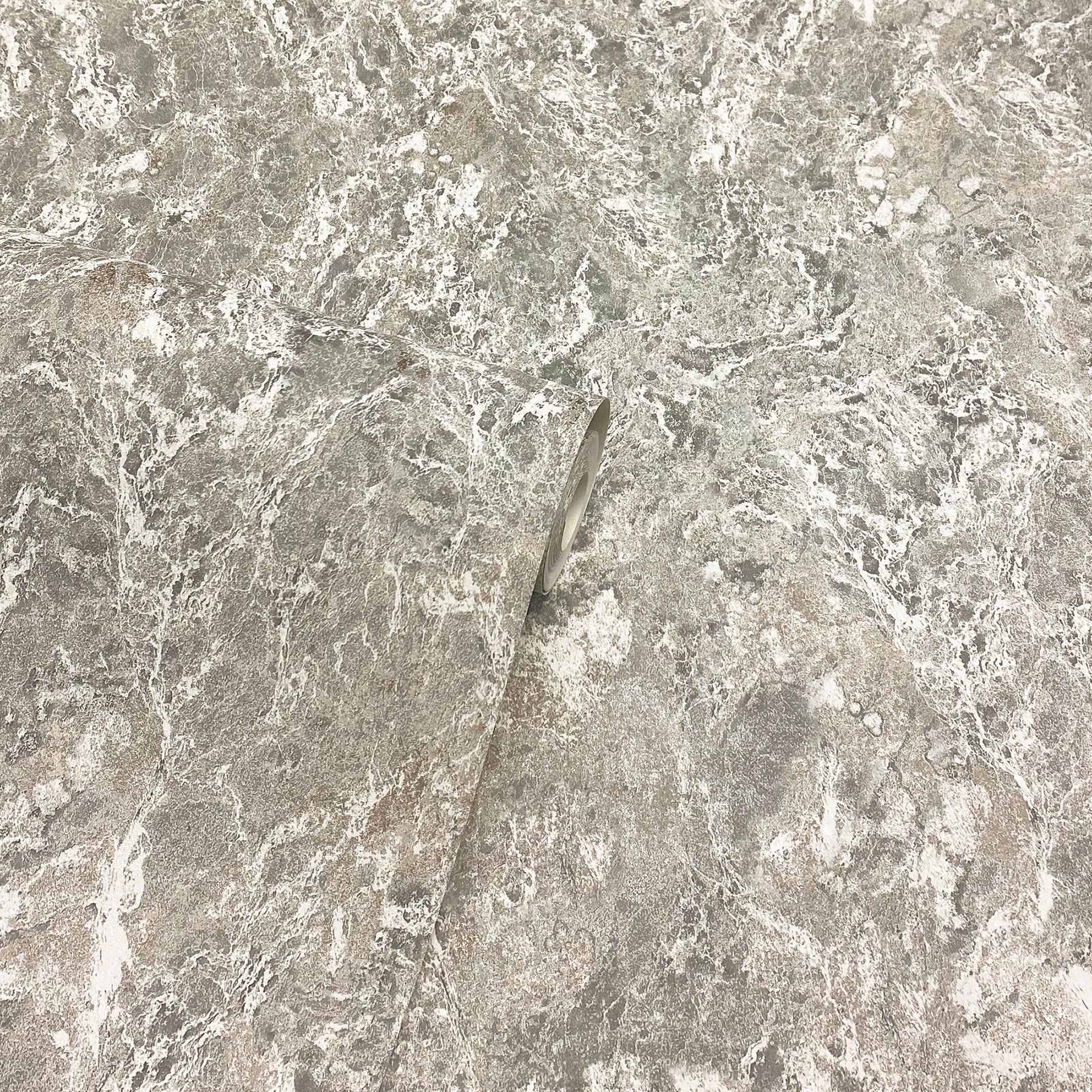 Close-up of grey marble surface with a slim metallic shard embedded diagonally.