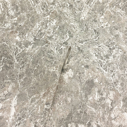 Close-up of grey marble surface with a slim metallic shard embedded diagonally.