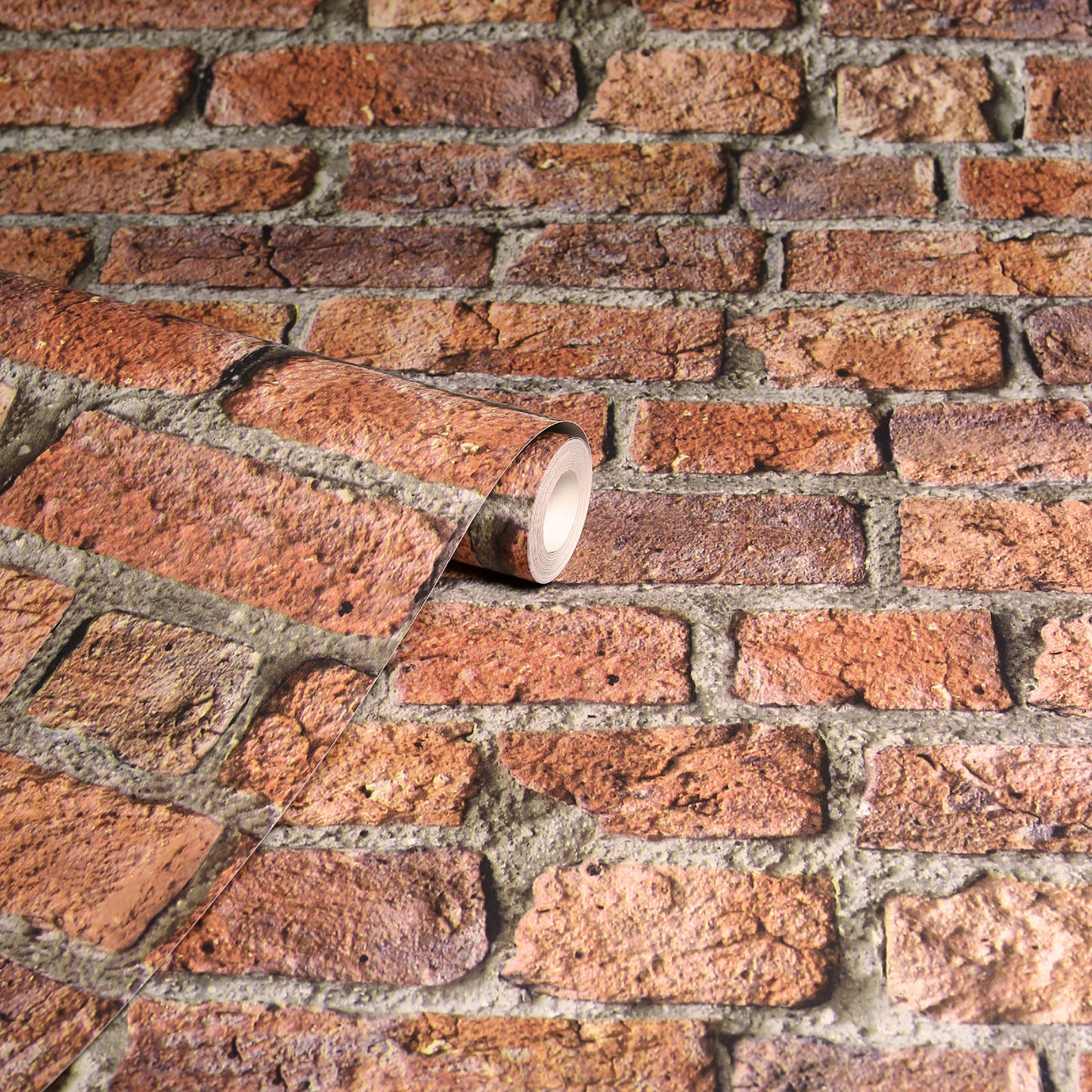 Rolled brick-pattern wallpaper sample with red-brown bricks and a white-core roll on a brick surface.