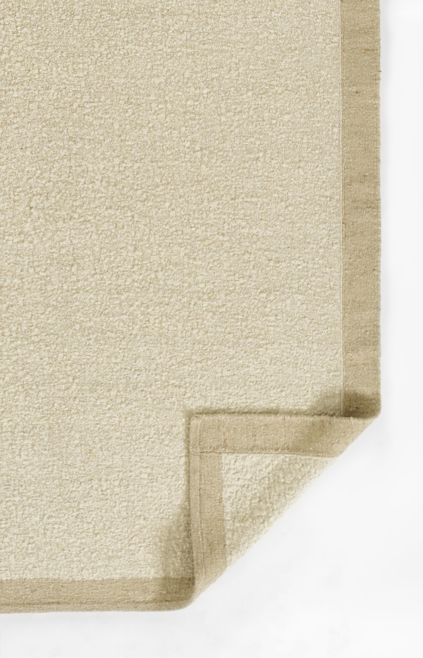 Beige textured runner rug with folded corner and darker beige binding along the edge.