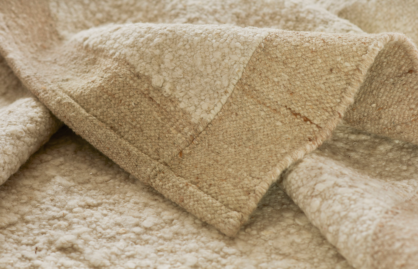 Beige sherpa-style rug with quilted rectangular panels; soft plush texture for cozy home decor.