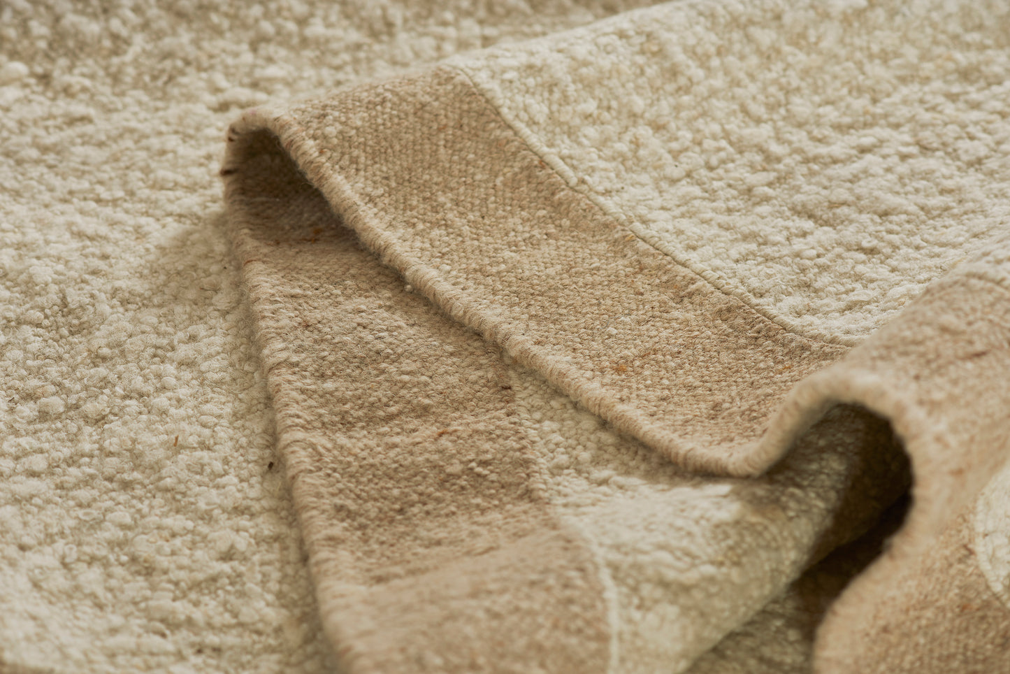 Beige bath towel with soft terry cotton texture, folded edge, cozy home spa use.