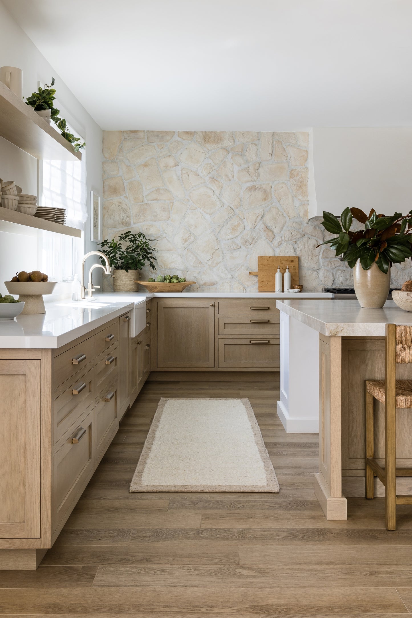 Light-toned rug on the floor with nearby potted plants in an airy Scandinavian-style living space.