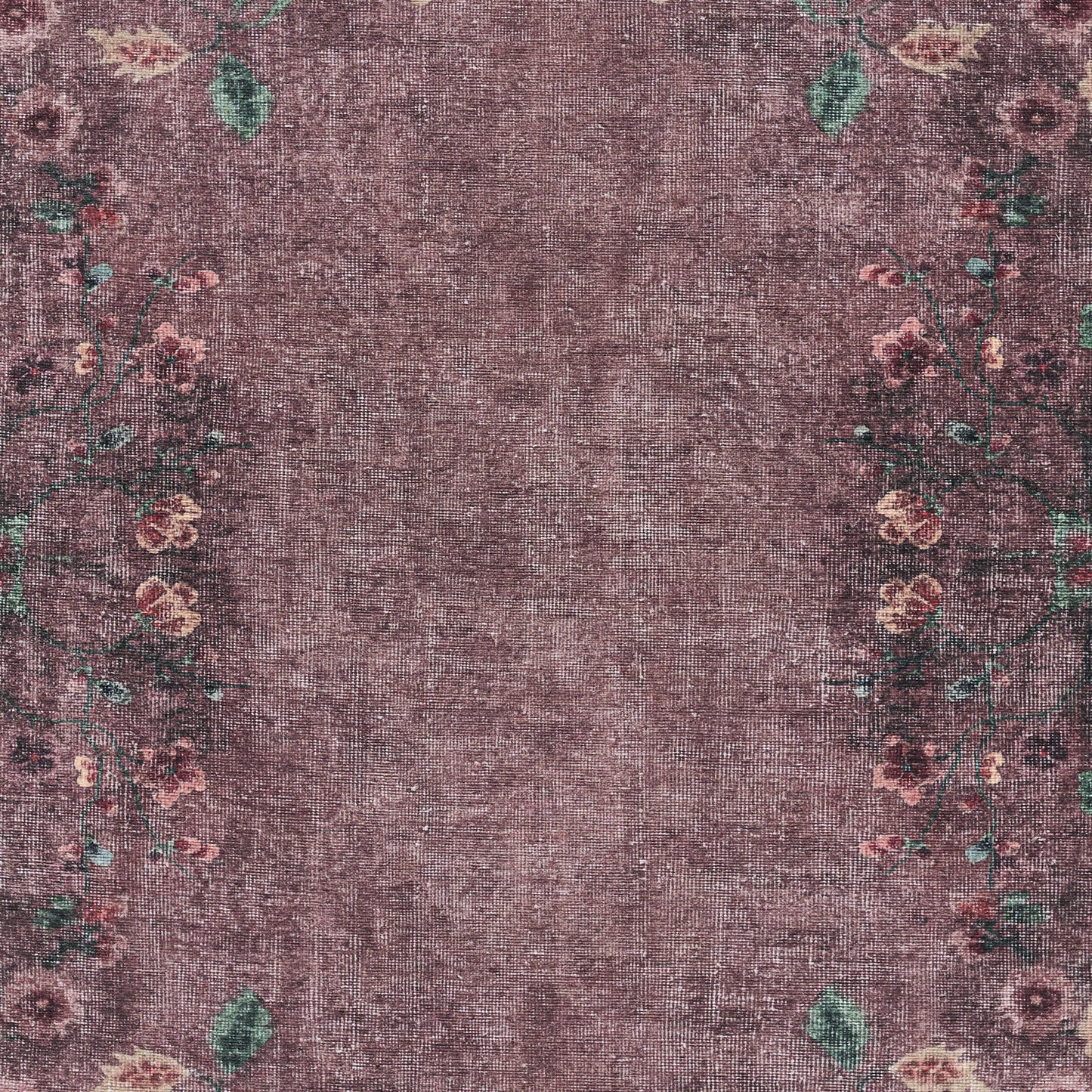 Purple distressed area rug with faded center and pink floral border with green leaves.