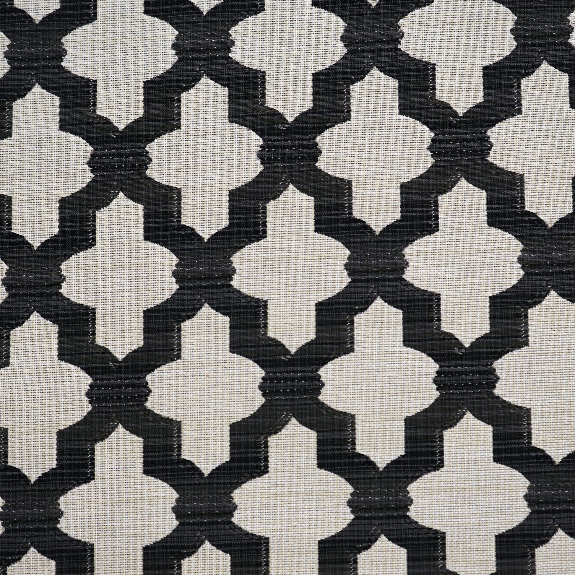 Black quatrefoil lattice on cream woven fabric; modern geometric upholstery textile.