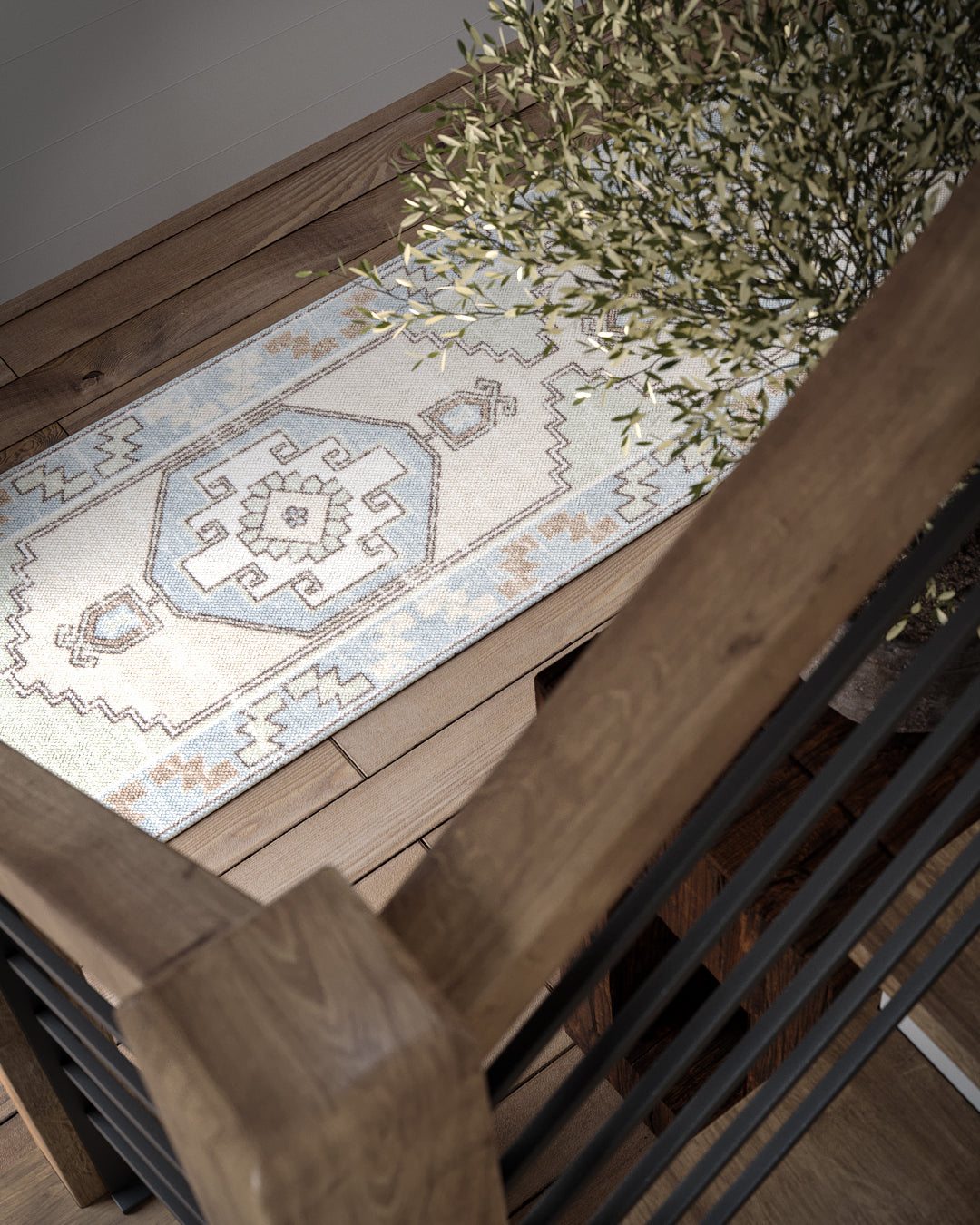 Boho geometric runner rug in blue and beige on wooden staircase, with a plant nearby.