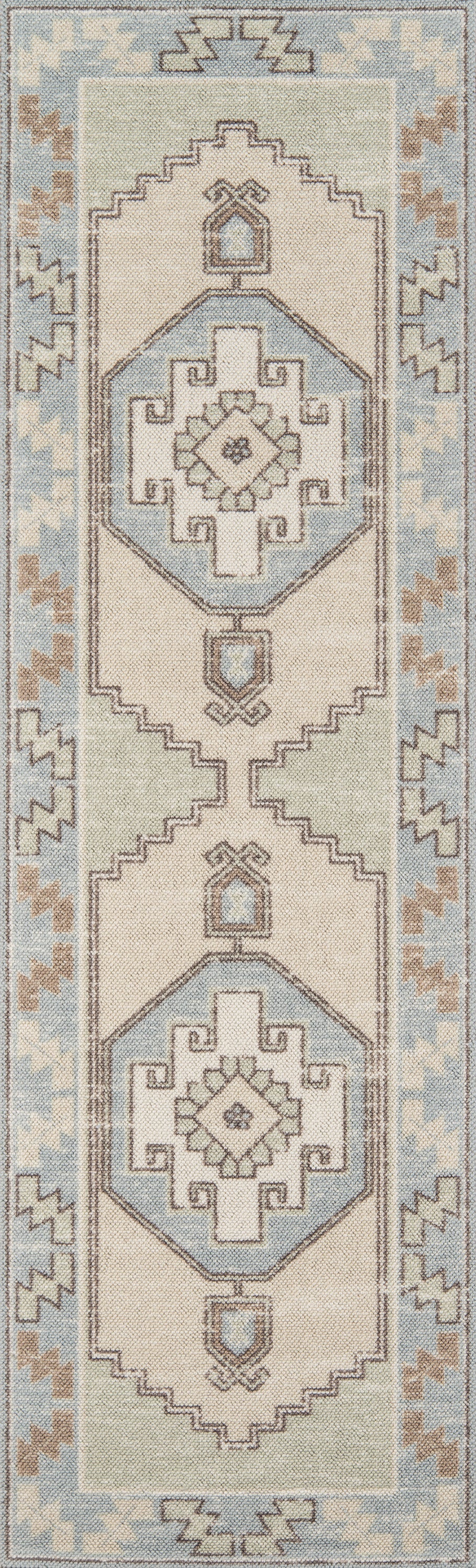 Anatolian-inspired wool rug featuring vertical geometric medallions in pale blue, ivory and taupe on a cream field.