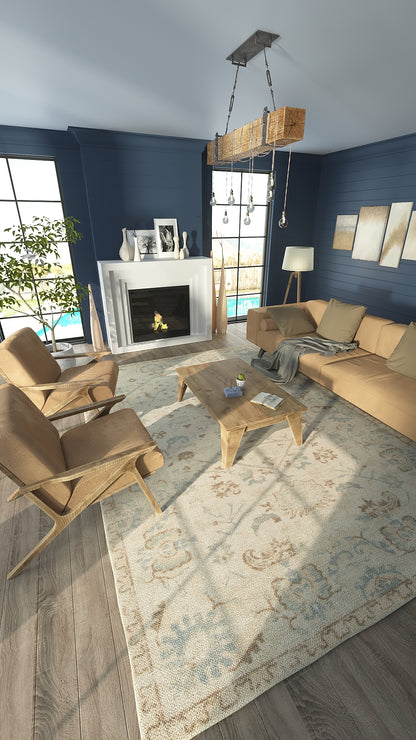 Cozy living room with navy walls, beige sofa and chairs, light wood coffee table, fireplace, chandelier, and patterned rug.