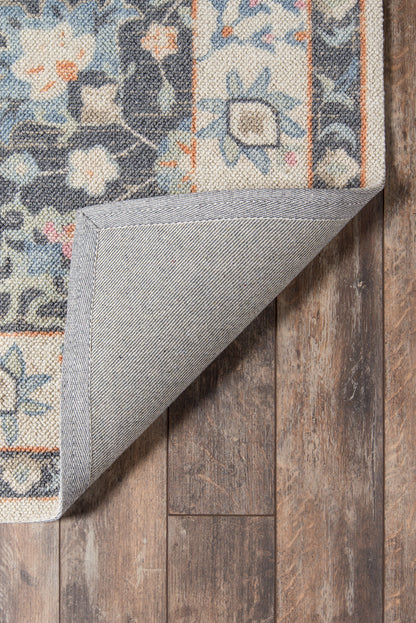 Rectangular oriental-style runner rug in blue & ivory with orange accents; folded corner reveals gray backing on dark wood floor.