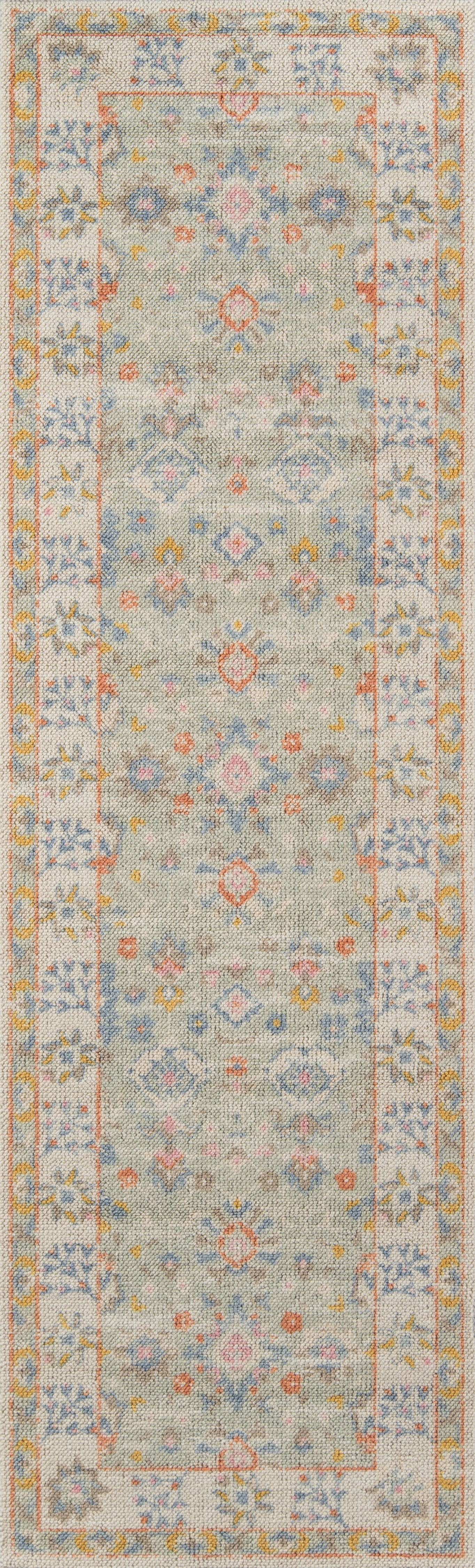 Anatolian-style area rug with a pale blue-gray field, yellow-toned border and soft pastel floral motifs.