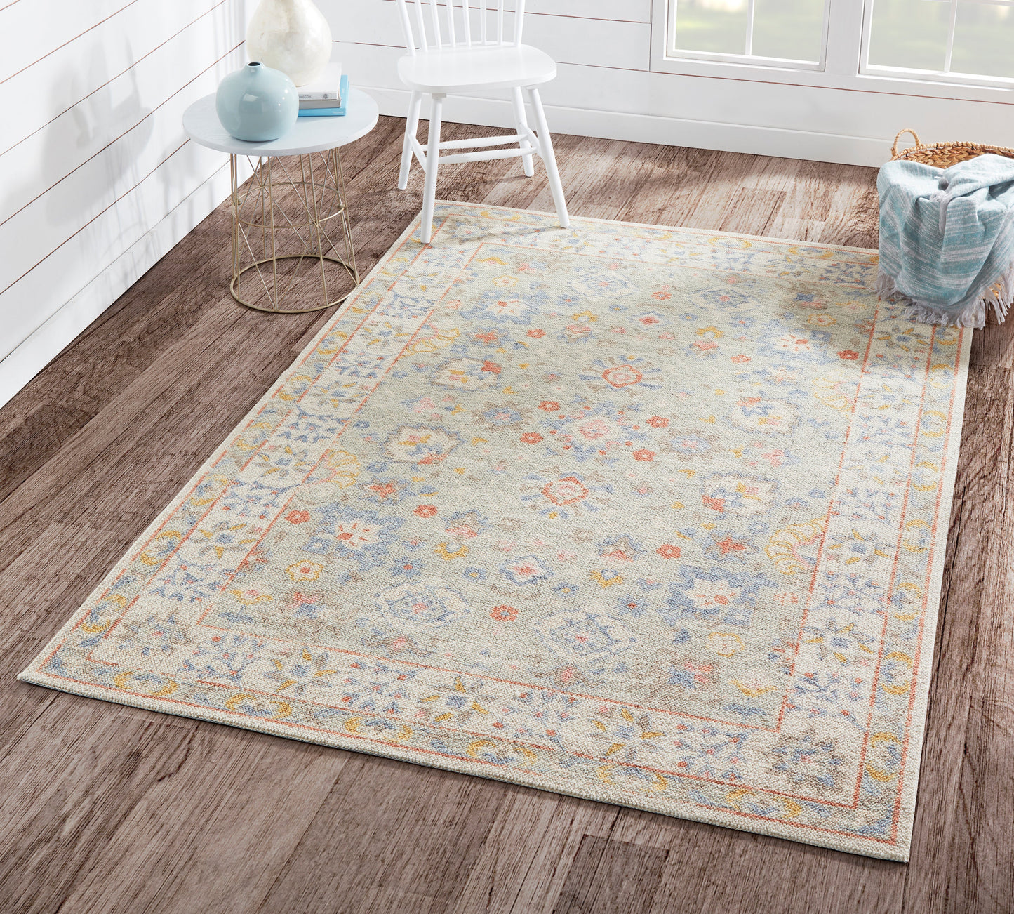 Pastel floral area rug with pale blue-gray field, pink and yellow blooms, decorative border; traditional style.